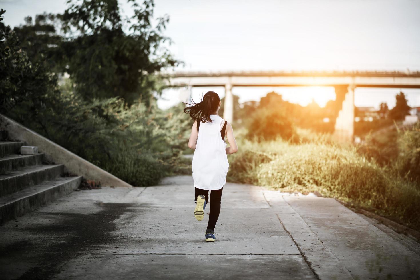 en ung glad kvinnlig löpare som joggar utomhus foto