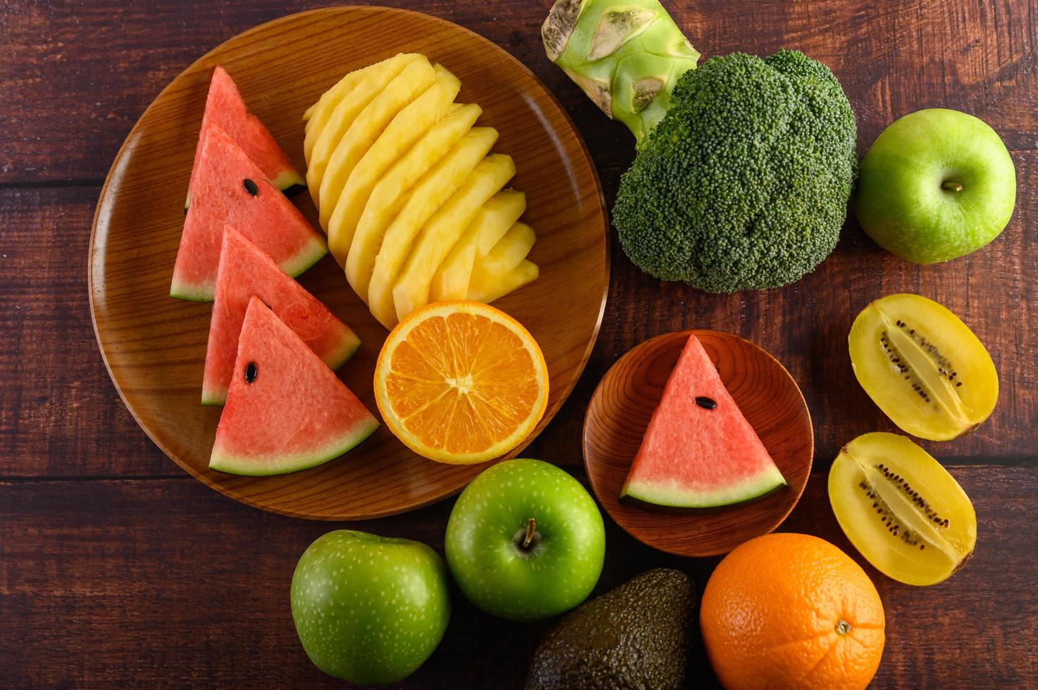 färgrik vattenmelon, ananas, apelsiner med avokado och äpplen foto