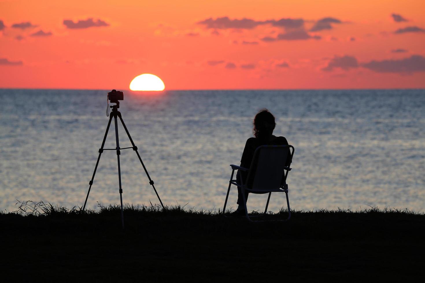 en fotografkvinna som tittar på solen foto