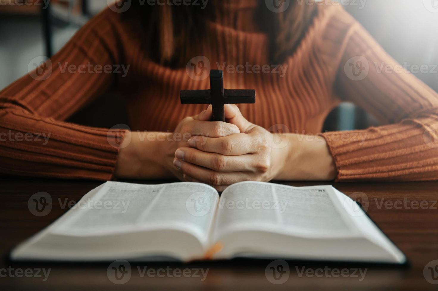 kvinna Sammanträde och studerar de scriptures.the trä- korsa i de händer. kristen utbildning begrepp de helig skrifterna öppen foto