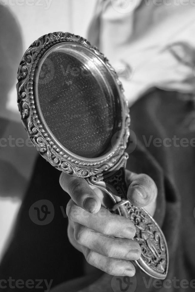kvinna hand innehav en spegel i svart och vit foto