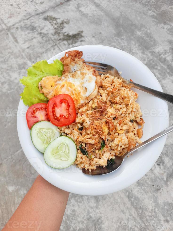 asiatisk man innehav en typisk indonesiska mat, nämligen friterad ris foto