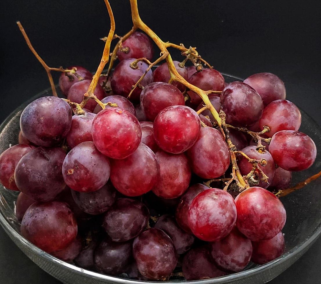 porträtt av vitis vinifera eller vindruvor i glas skål isolerat på svart bakgrund, stänga upp se. foto