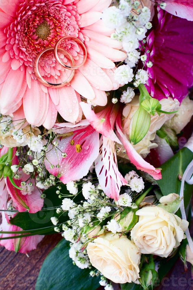 bröllop ringar och många färgrik blommor med ro bukett foto