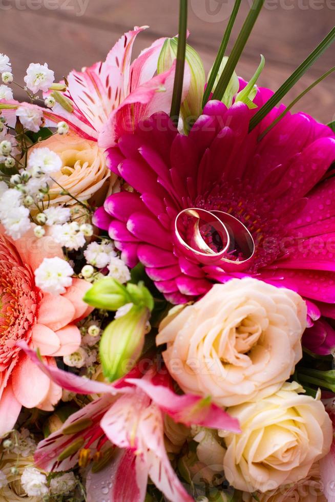 bröllop ringar och många färgrik blommor med ro bukett foto