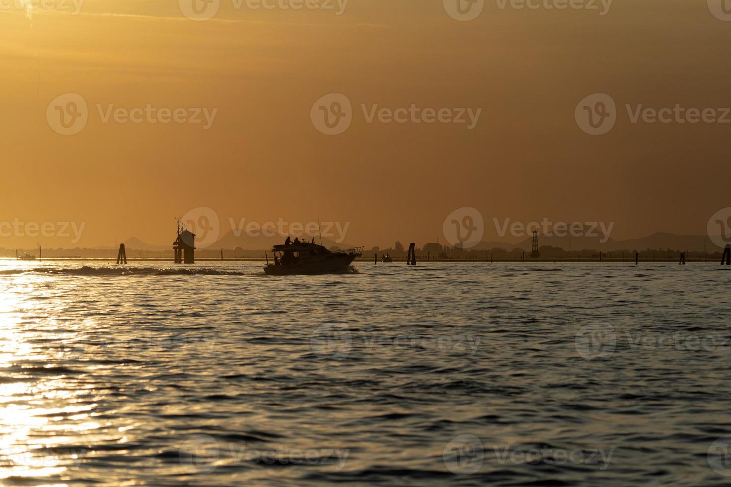 solnedgång i Venedig lagun chioggia hamn från en båt foto