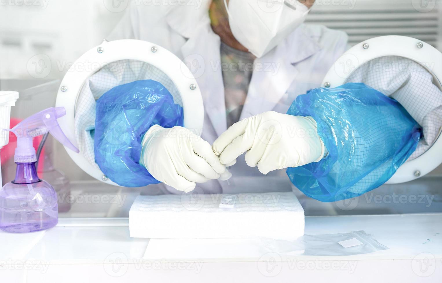 stänga upp till de sudd handskar på de asiatisk medicinsk personal är bearbetning coronavirus eller covid-19 testa i de negativ rum tryck. foto