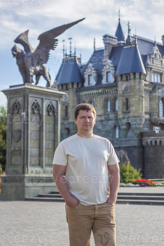 en man på de bakgrund av en gotisk stil slott. de territorium av de turist komplex foto