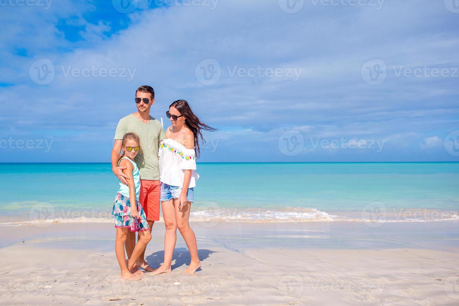 Lycklig familj på de strand under sommar semester foto