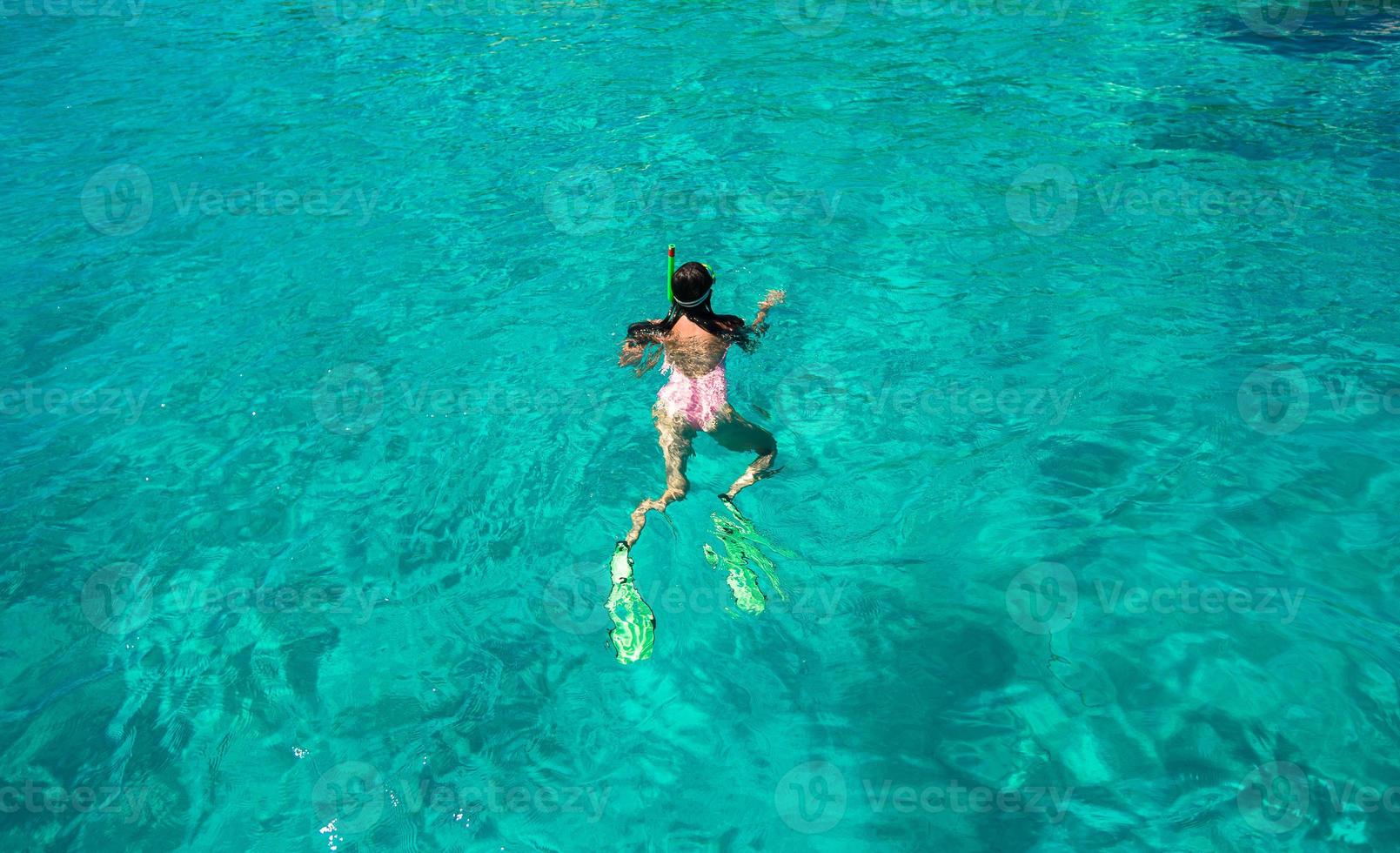 ung kvinna snorkling i tropisk vatten på semester foto