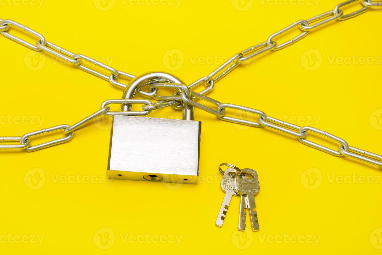 låsa på en kedja på en gul bakgrund, en knippa av nycklar lögner närliggande foto