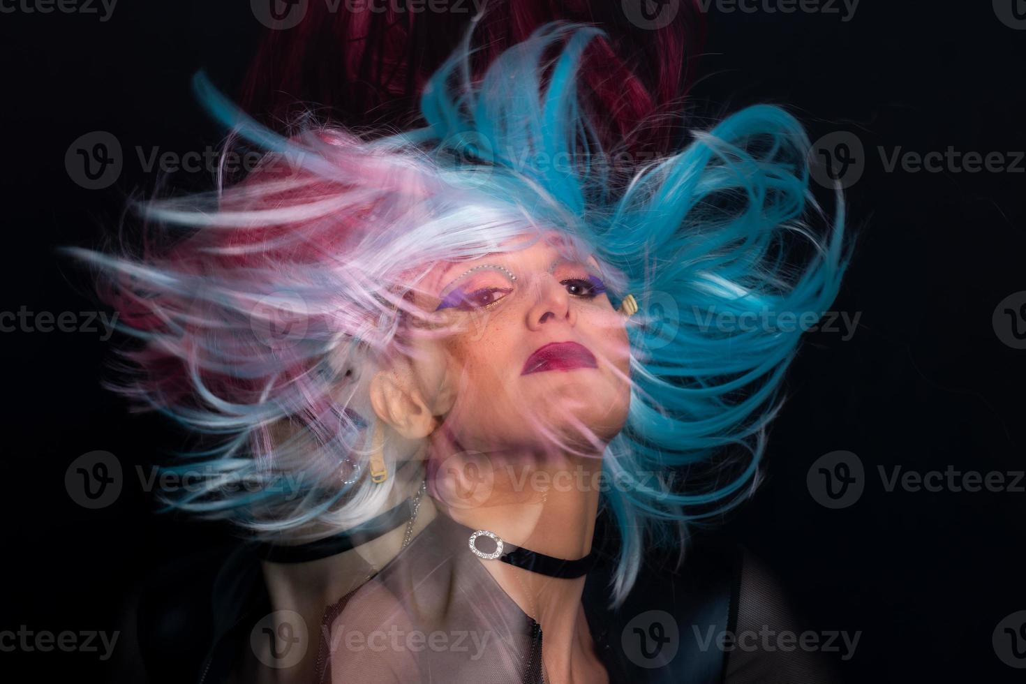 en flicka på en svart bakgrund med trippel- exponering och hår med tre peruker den där flytta foto