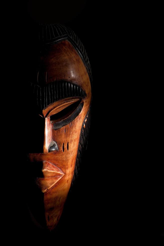 afrikansk mask. resa souvenirer isolerat på svart bakgrund foto