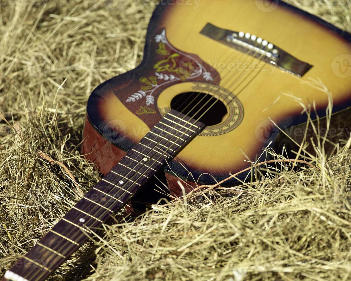 ett gammal gitarr om i en hö bal foto