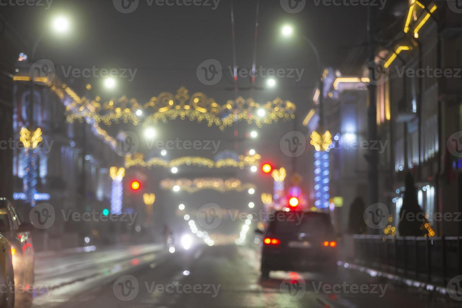 suddig kväll stad med bilar och lampor av flerfärgad lyktor. foto