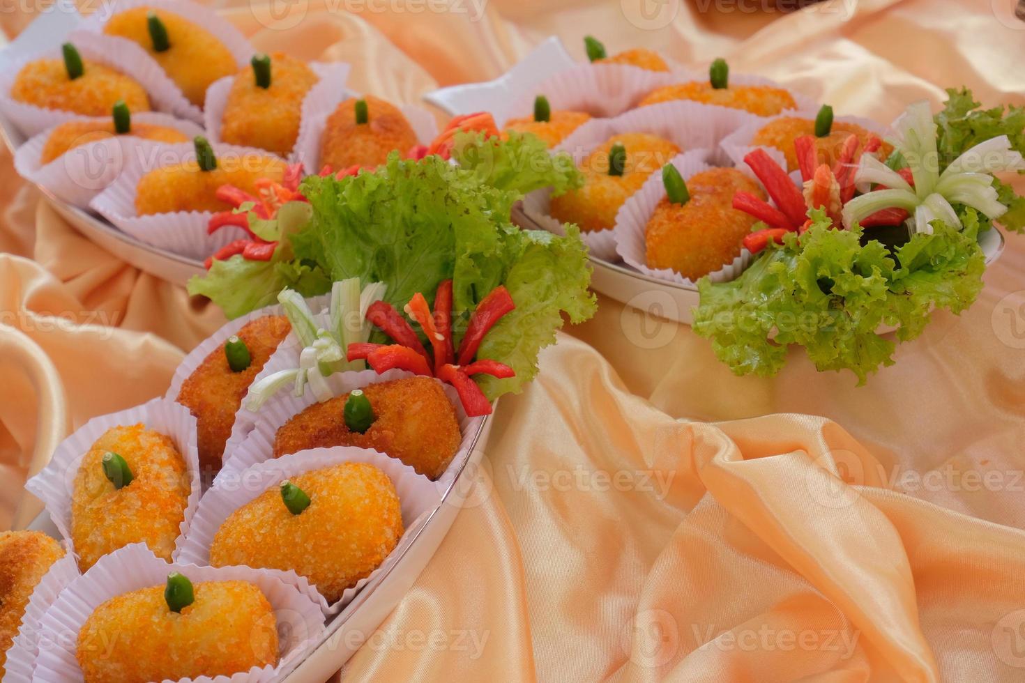 kroket kentang är en traditionell mellanmål från Indonesien. eras i trä- tallrik med grön chili. utsökt indonesiska traditionell kroket kentang med chili foto