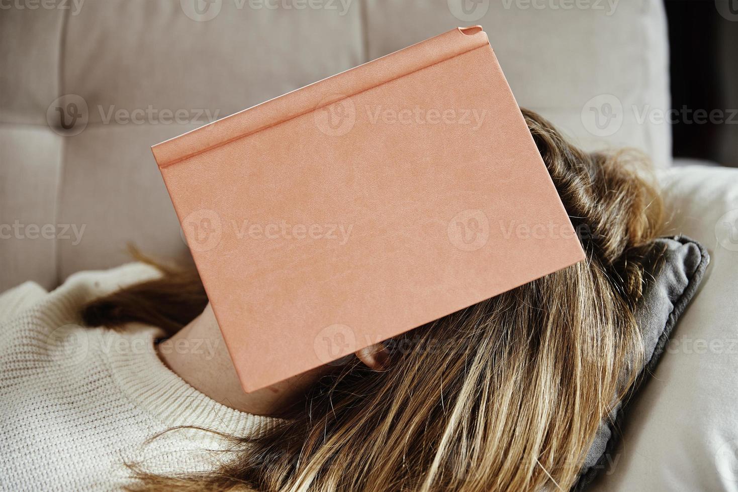 kvinna sover på soffa med bok foto