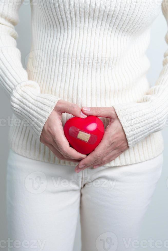 kvinna innehav röd hjärta form. graviditet, reproduktiv systemet, menstruation, och gynekologi begrepp foto