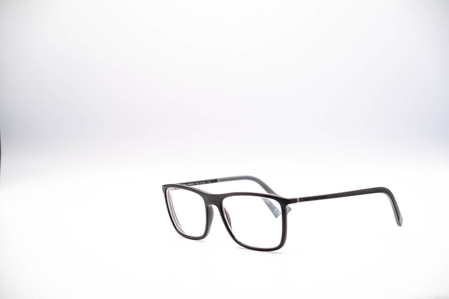 svart glasögon med en tjock fälg fotograferad mot en vit bakgrund, under en Foto skjuta i januari 2023