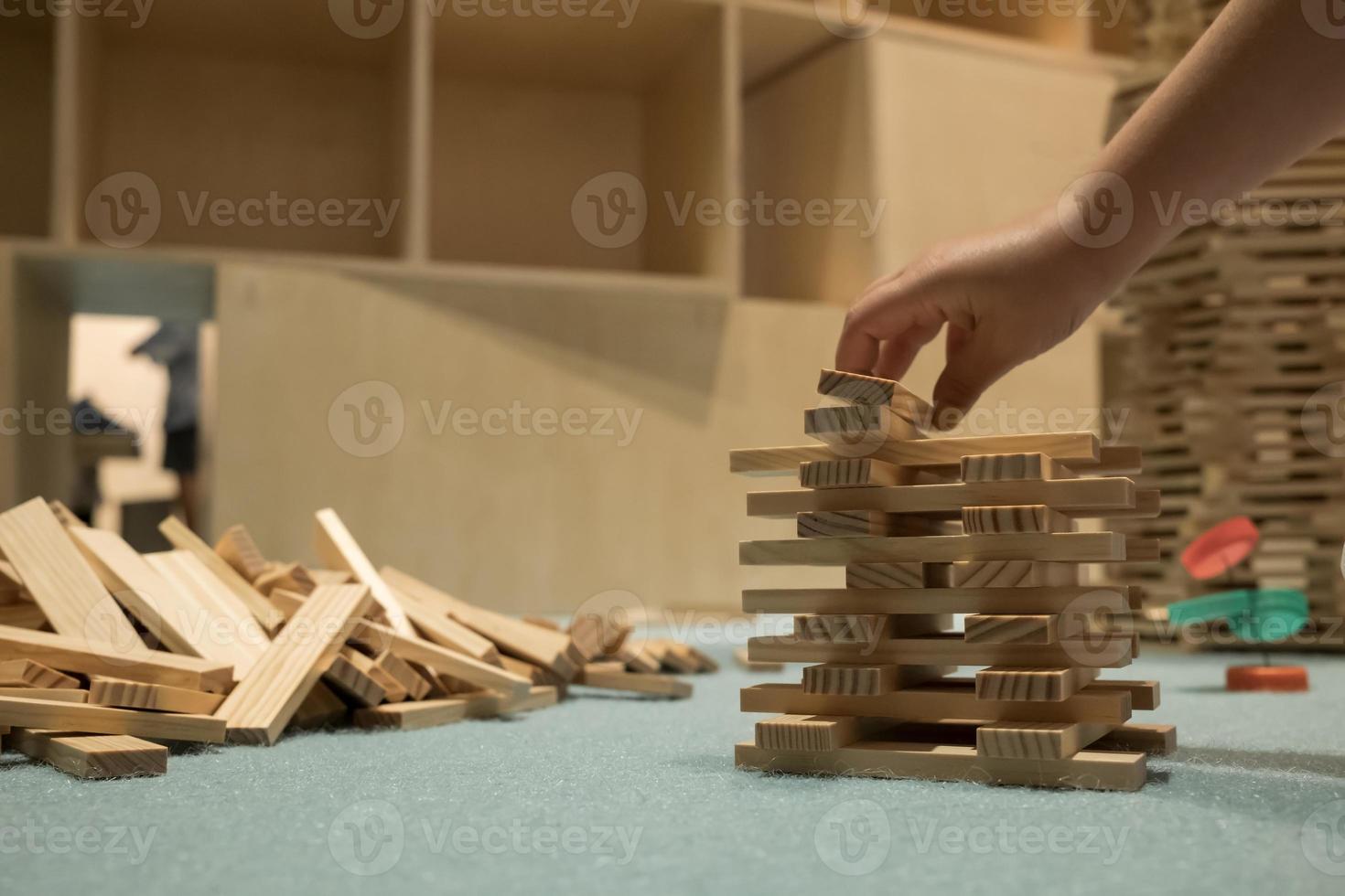 barn bygger en jenga torn med trä- block. foto