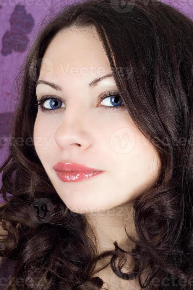 porträtt av de ung kvinna på en violett bakgrund foto