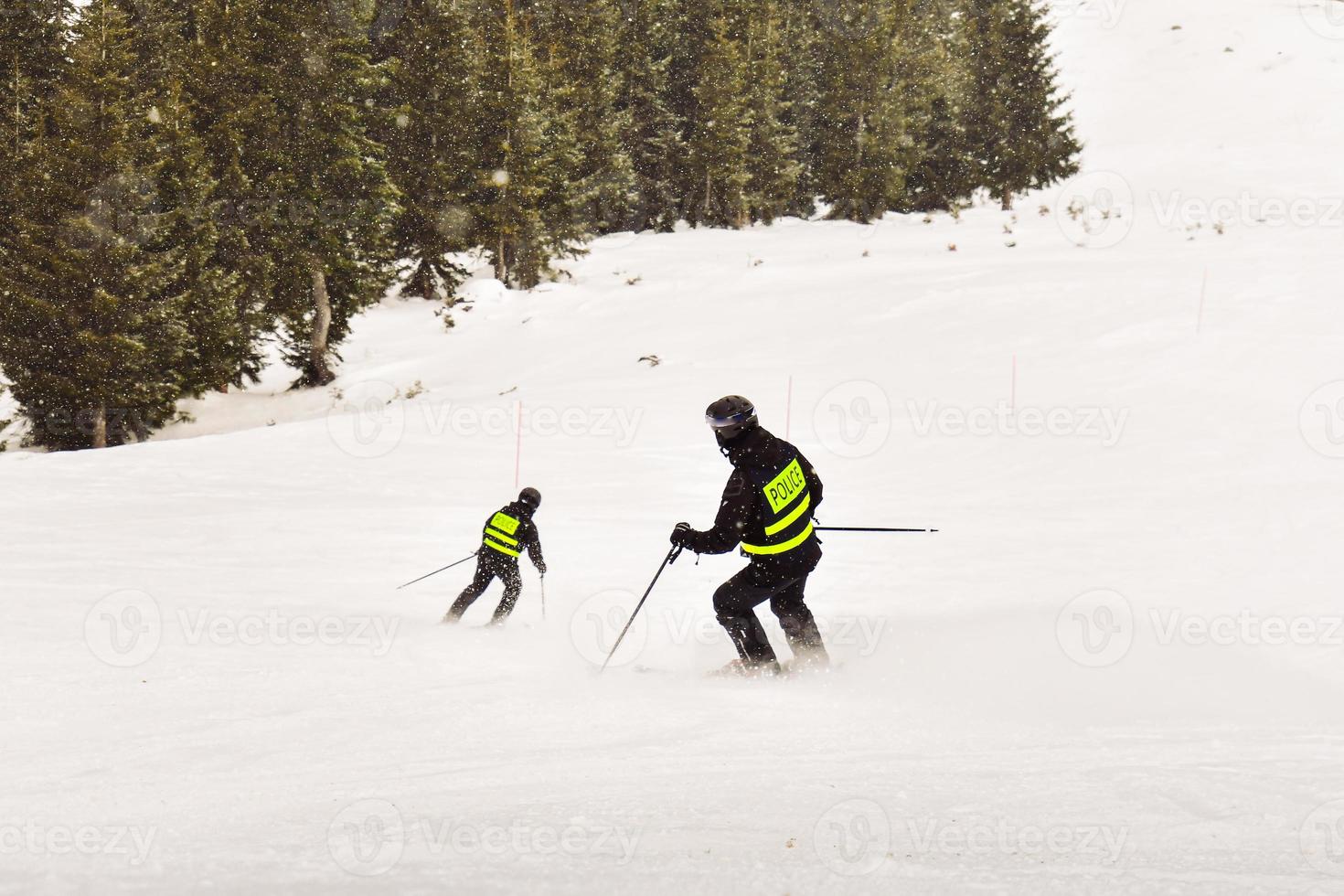 åka skidor polis skidåkare skidåkning gå utför. backe kontrollera. åka skidor arbetssätt högtider. foto