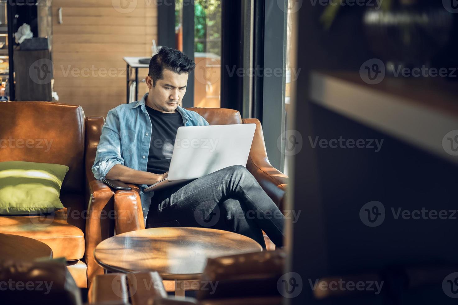 asiatisk frilansare i blazer med bärbar dator i Kafé nära fönster yrke är bloggare, frilans översättare och författare. frilans översättare Arbetar i kaffe affär. uppkopplad inlärning foto