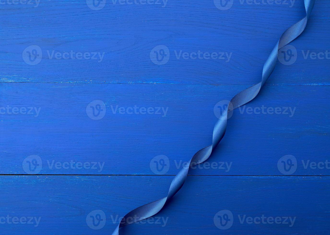blå silke tunn band vriden på en blå trä- bakgrund foto