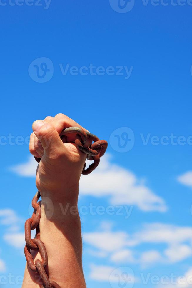 manlig hand innehar en rostig metall kedja foto