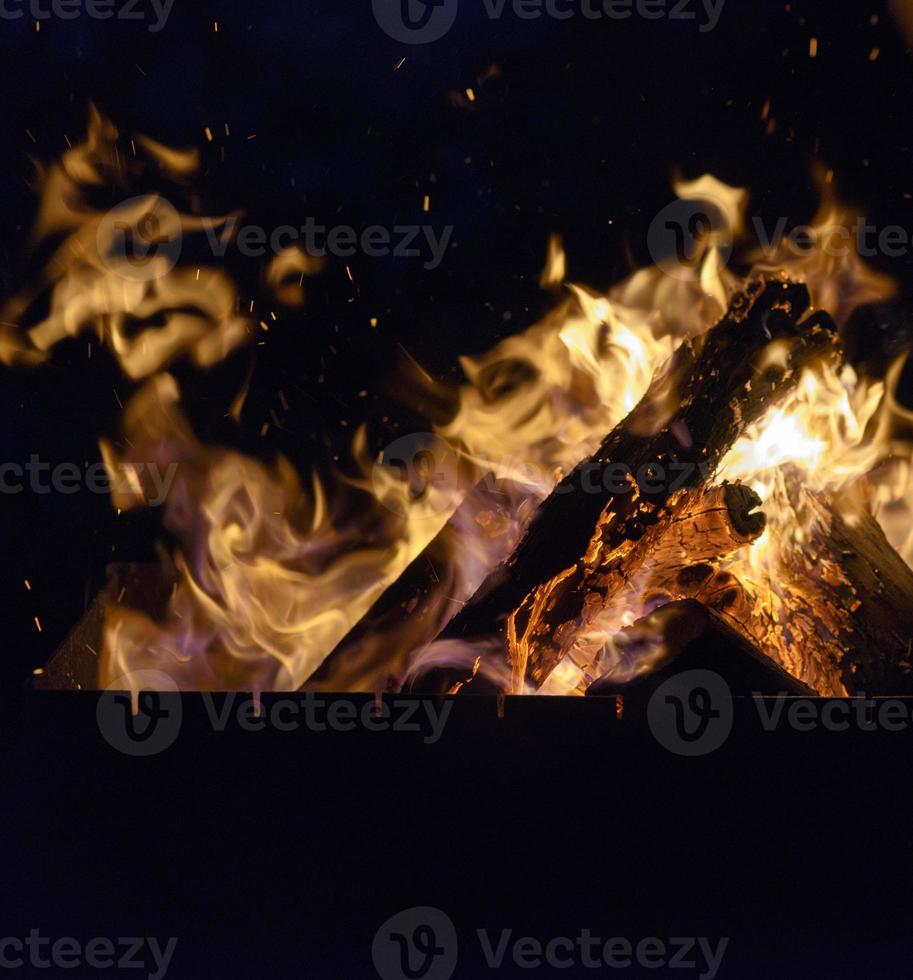 brinnande trä- loggar i de brand på natt foto