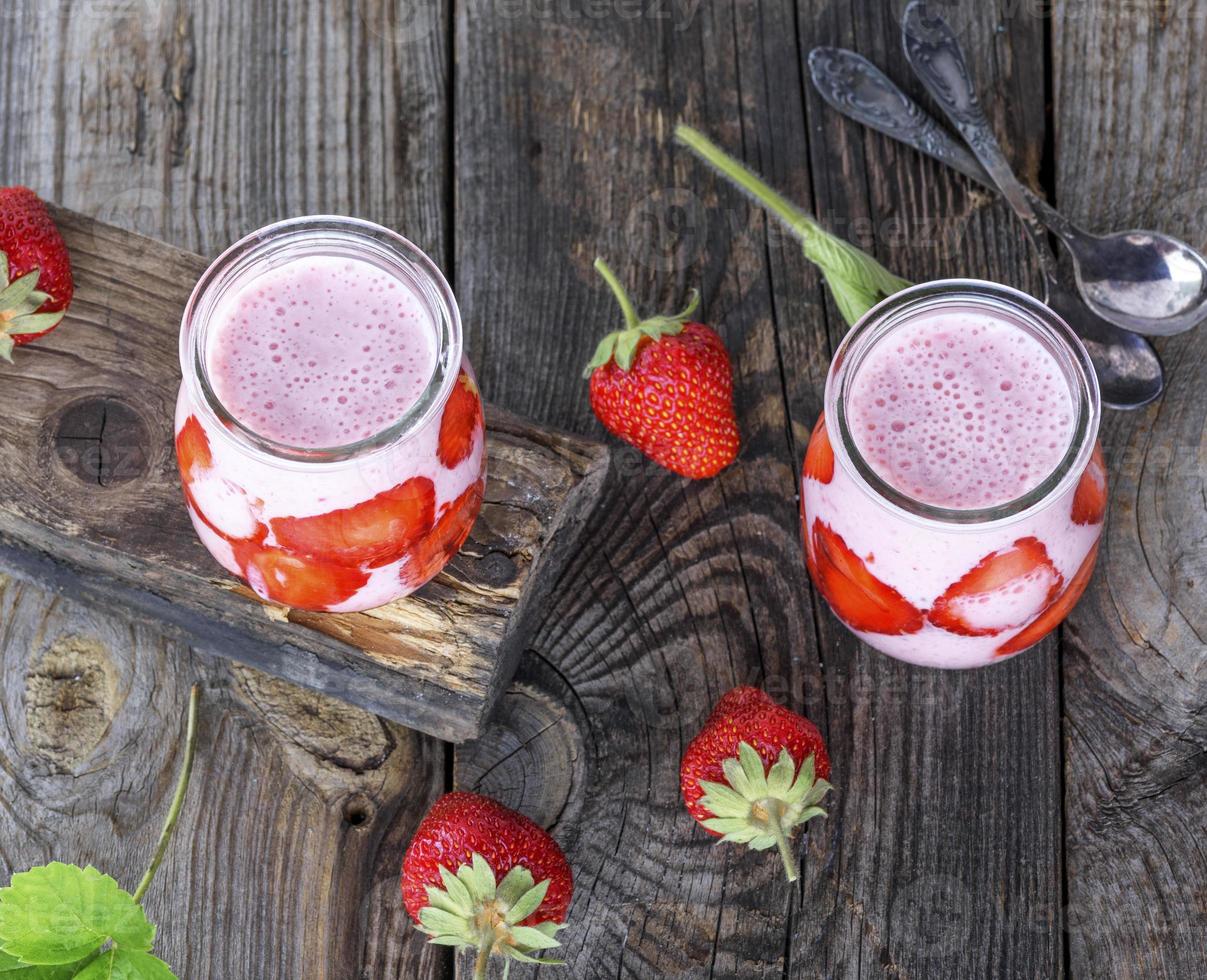 yoghurt med färsk jordgubbar i en glas burk foto