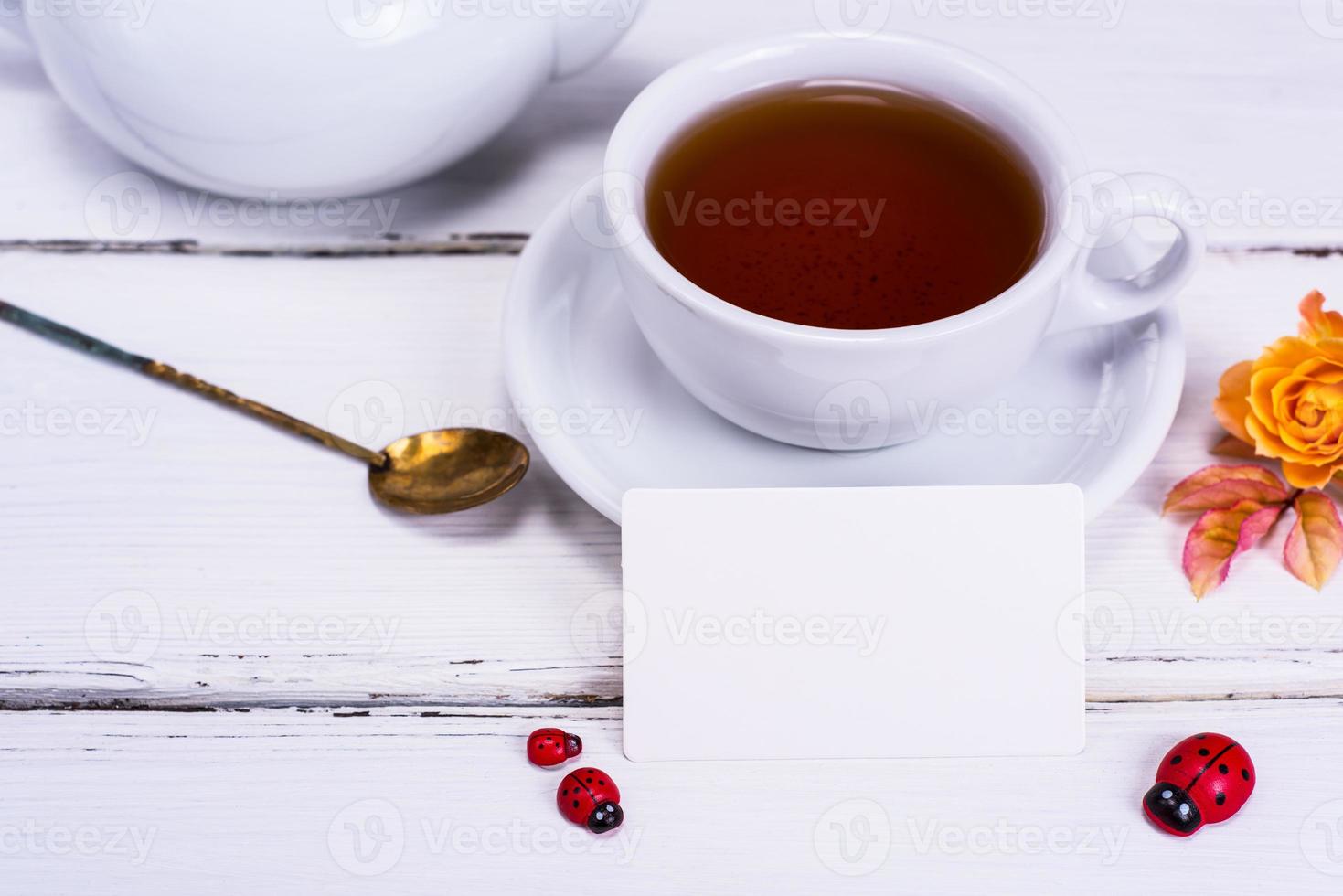svart te i en runda vit kopp med en fat foto
