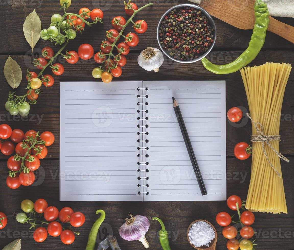 tom anteckningsbok med vit lakan, rå lång klistra och Ingredienser för matlagning foto