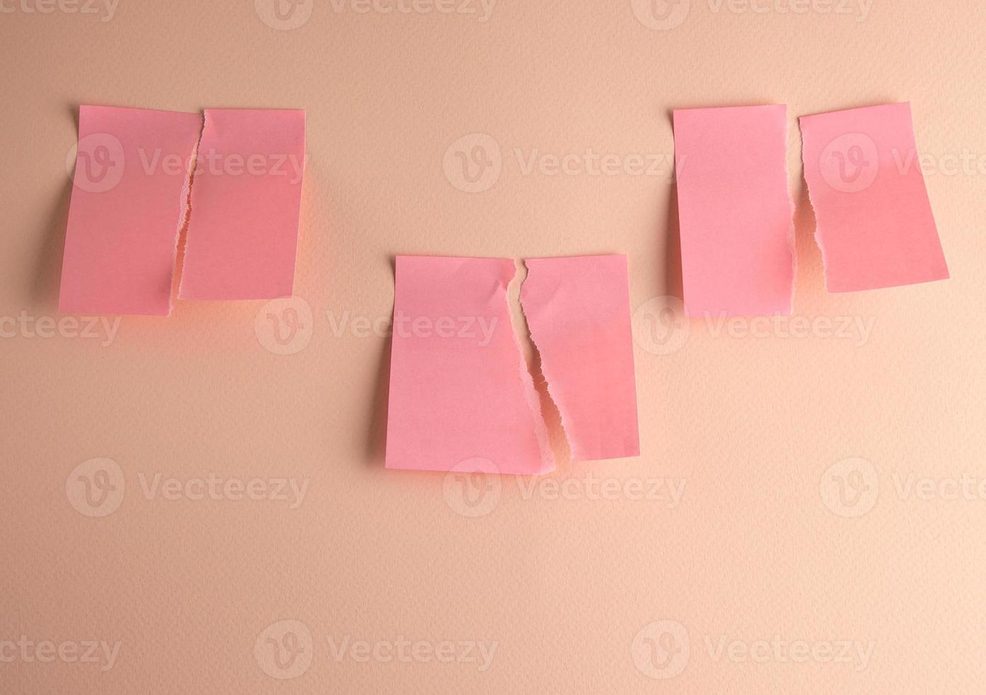tre papper rosa klistermärken rev i halv foto