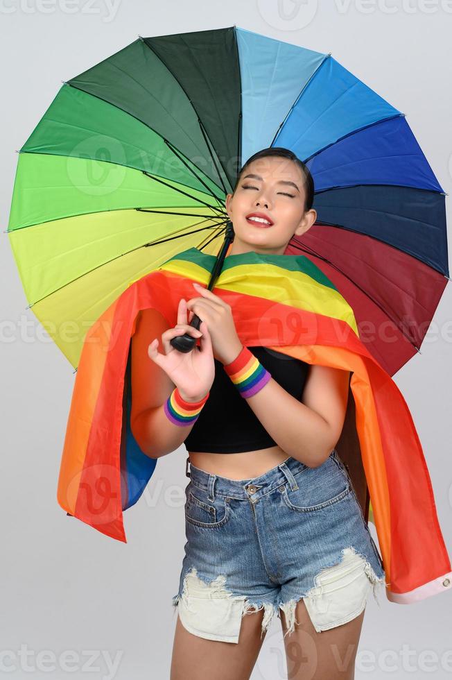 Söt kvinna lgbq utgör med färgrik paraply foto