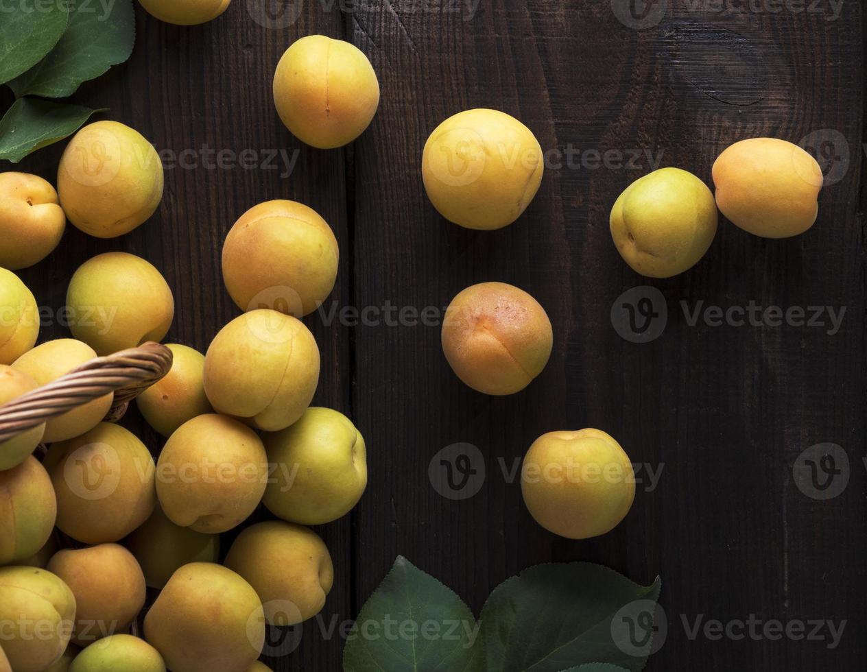 mogen gul aprikoser på en brun trä- tabell foto