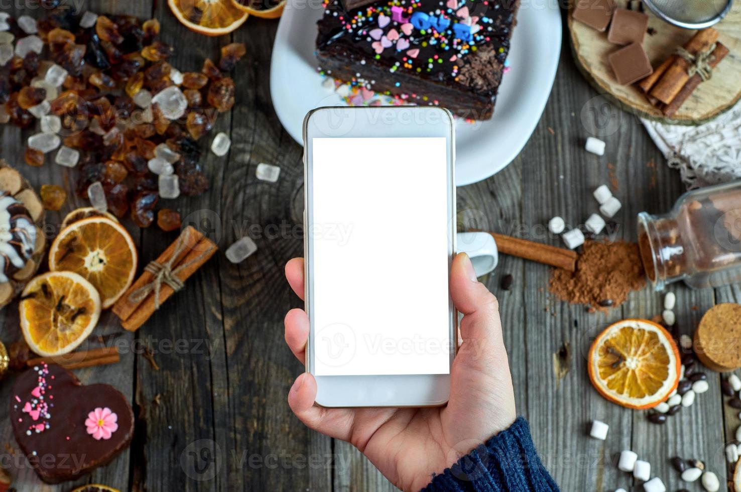 kvinna hand innehav en smart telefon på de tabell, vit tom skärm foto