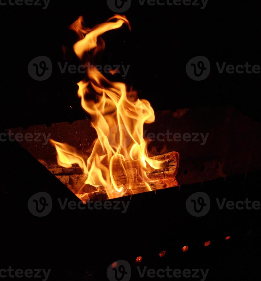 brinnande trä- loggar och stor orange flamma foto