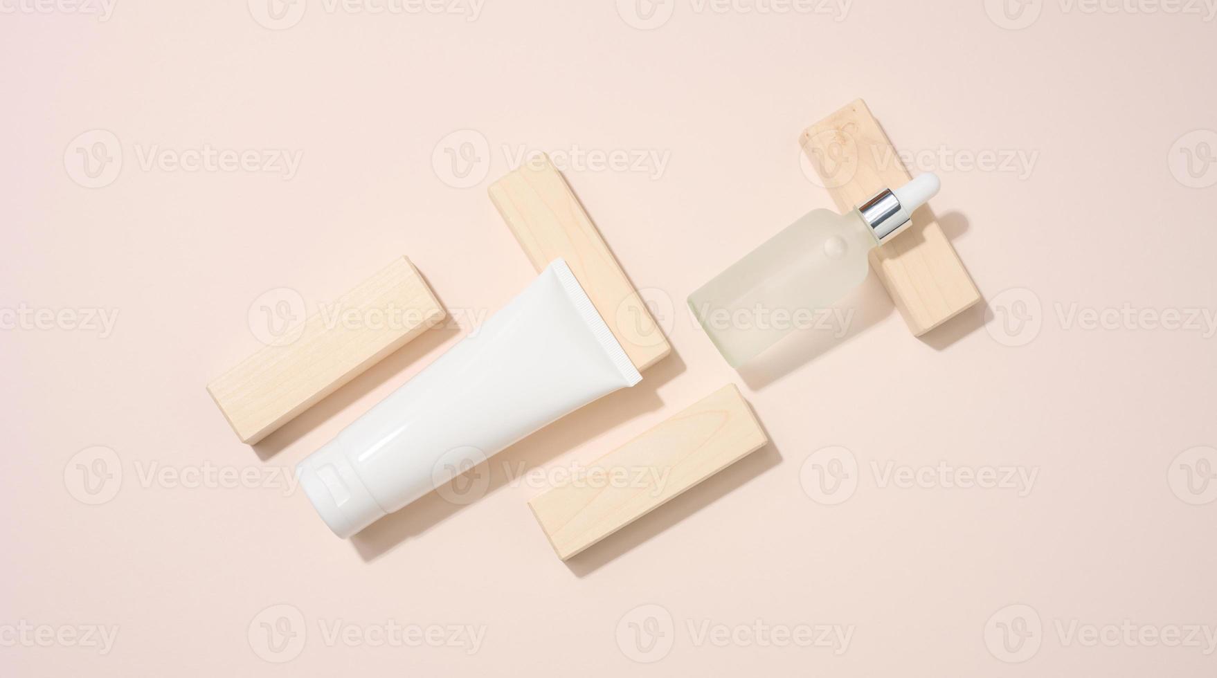 plast rör och vit glas flaska med pipett står på en beige bakgrund. kosmetika spa varumärke. förpackning för gel, serum, reklam och produkt befordran, falsk upp foto