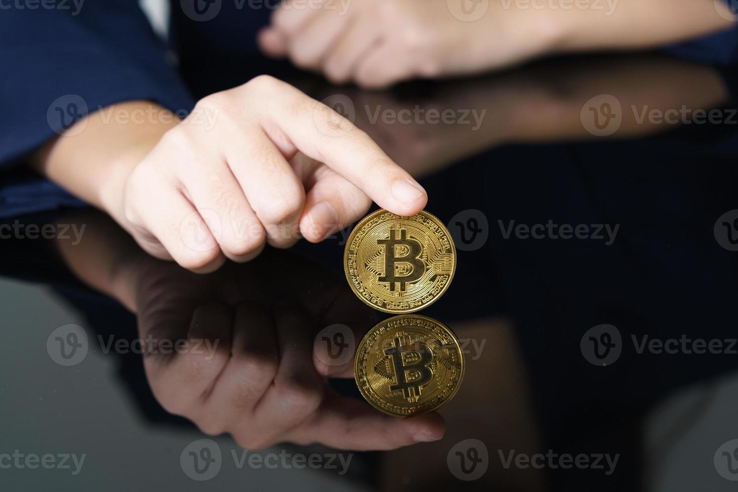 närbild av finger rörande gyllene bitcoin mynt foto