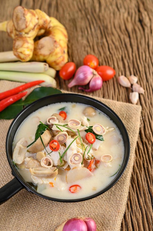 tom kha kai soppa med kaffir lime blad, citrongräs, rödlök, galangal och chili foto