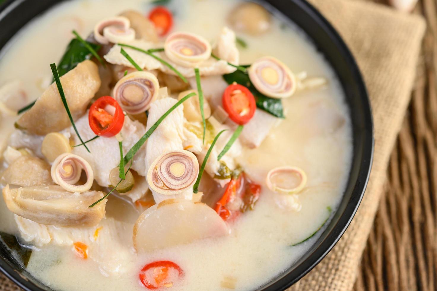 tom kha kai soppa med kaffir lime blad, citrongräs, rödlök, galangal och chili foto