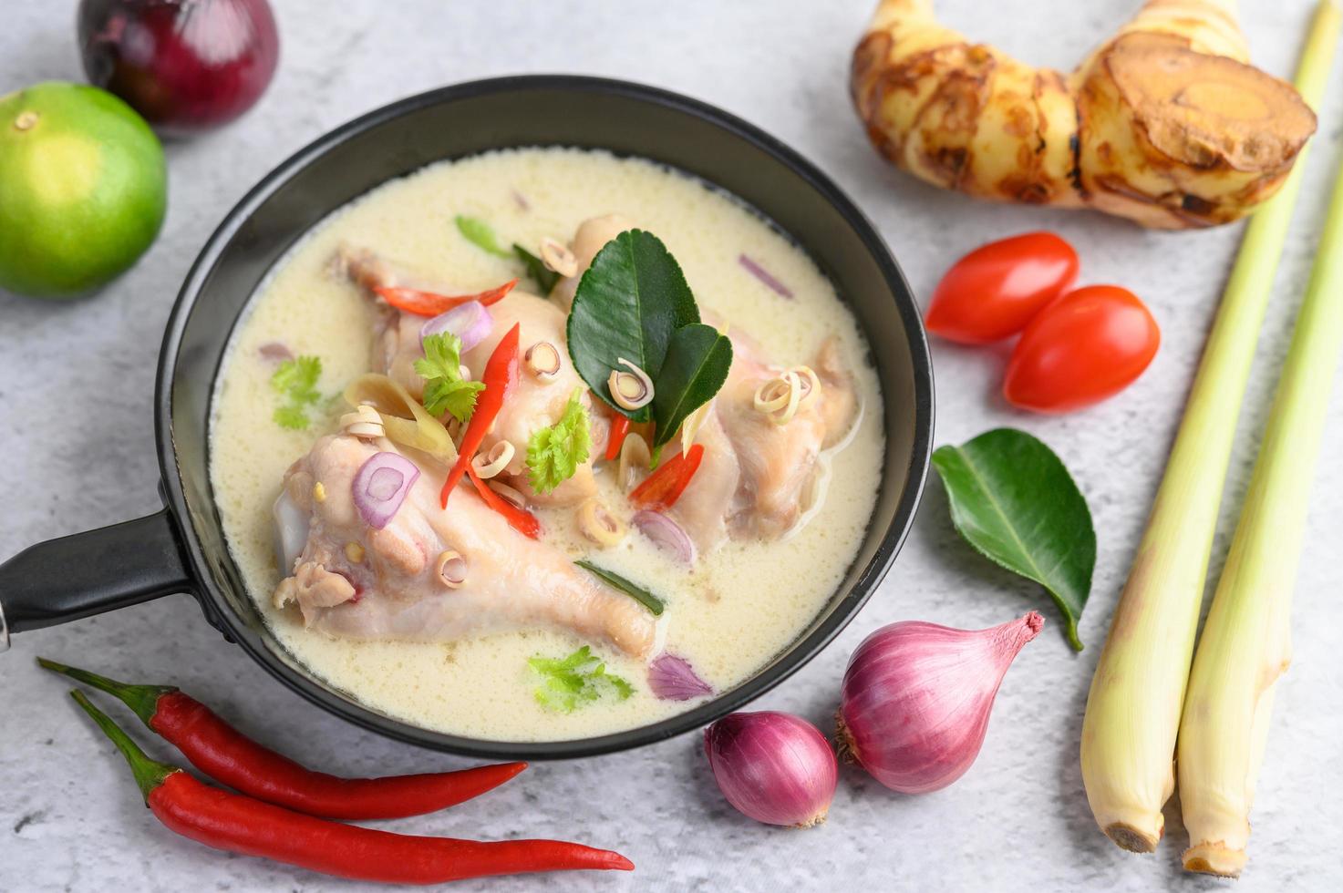 tom kha kai soppa med kaffir lime blad, citrongräs, rödlök, galangal och chili foto