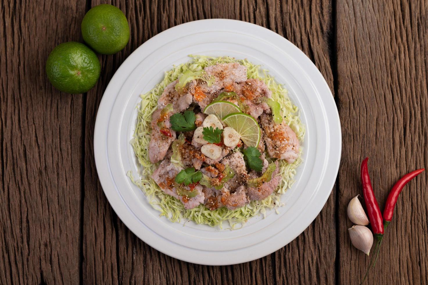 kryddig lime fläsk sallad med galangal, chili och tomater foto