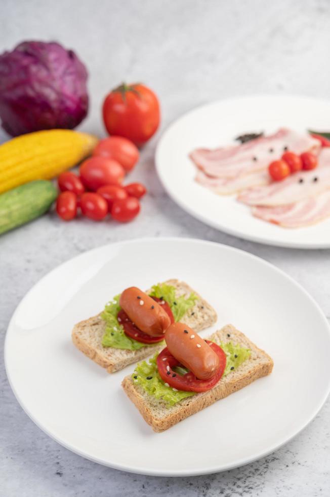 korv med tomater och sallad på bröd foto