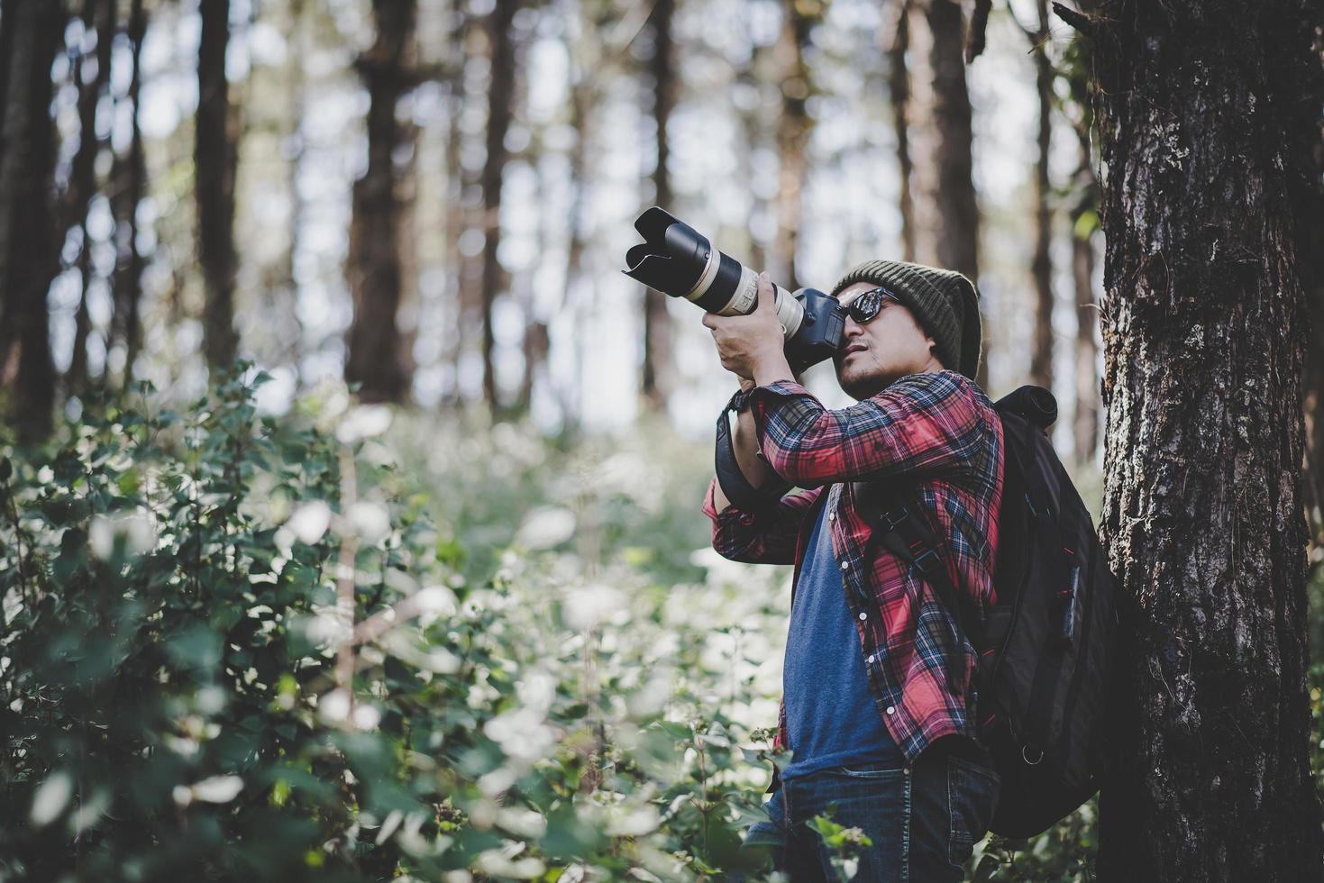 ung fotograf som tar bilder i skogen foto