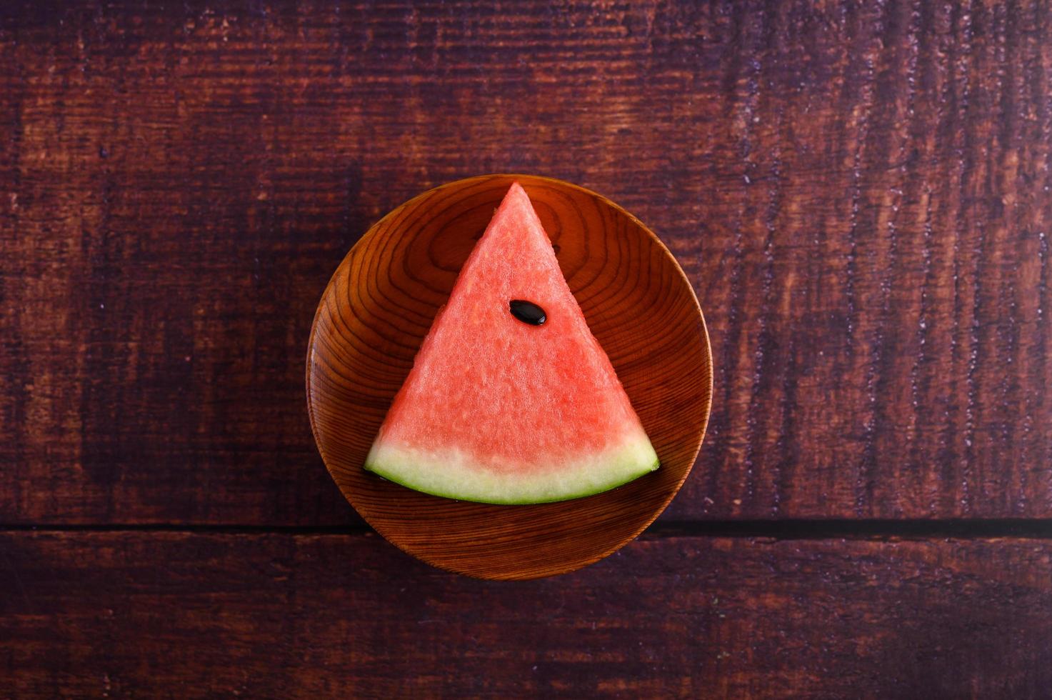 vattenmelon skuren i bitar på ett träbord foto