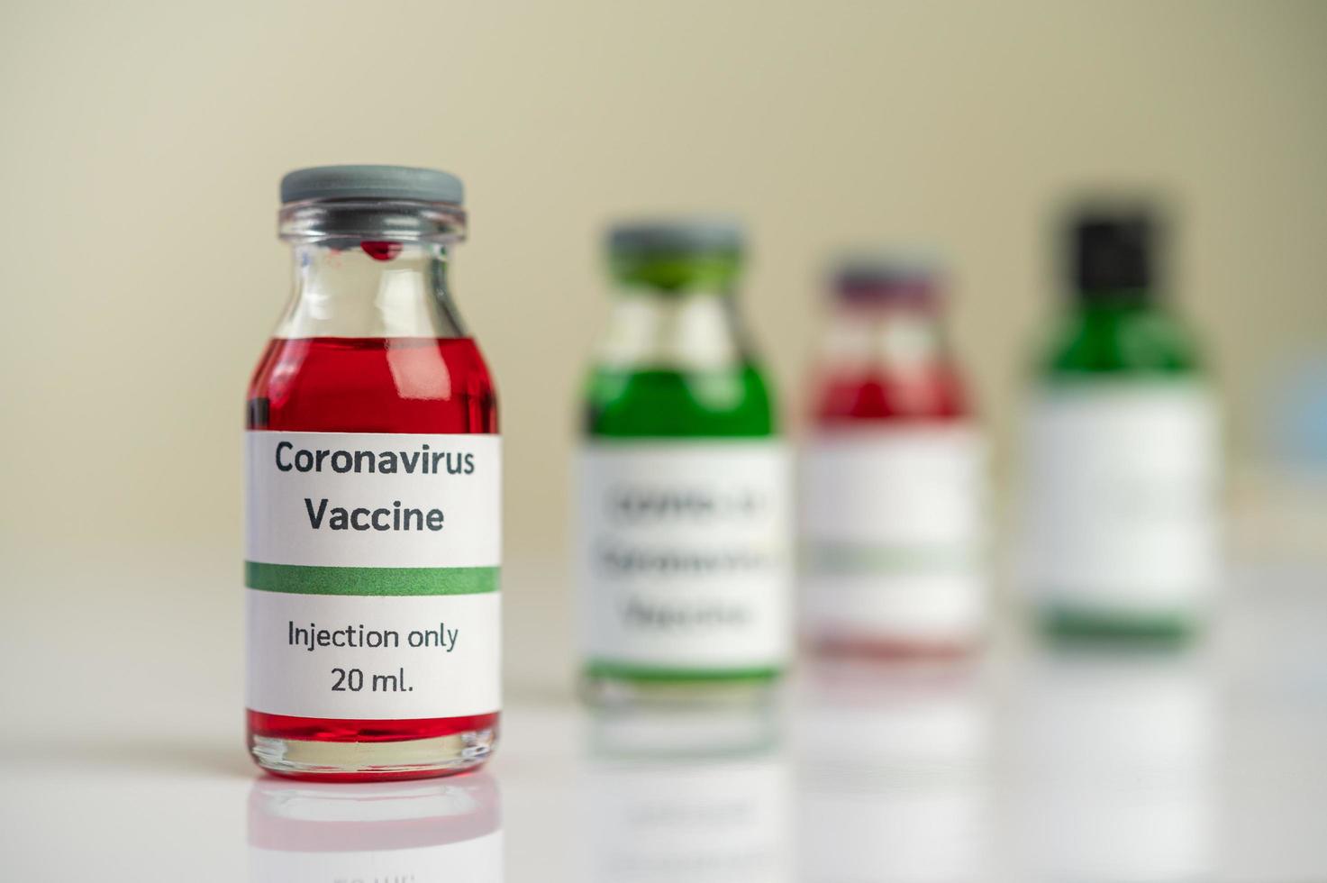 vaccinet mot covid-19 i röda och gröna flaskor foto