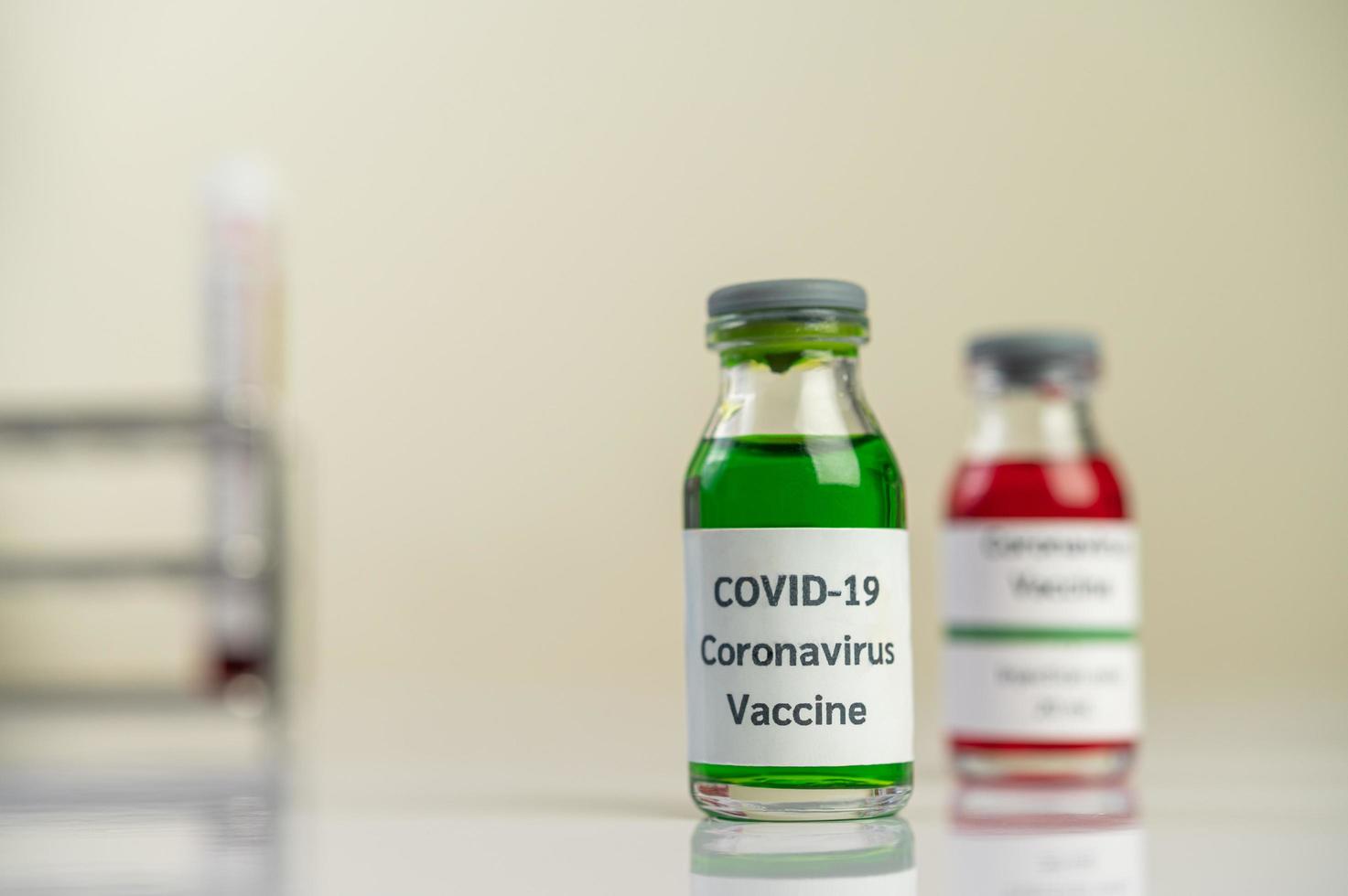 vaccinet mot covid-19 i röda och gröna flaskor foto