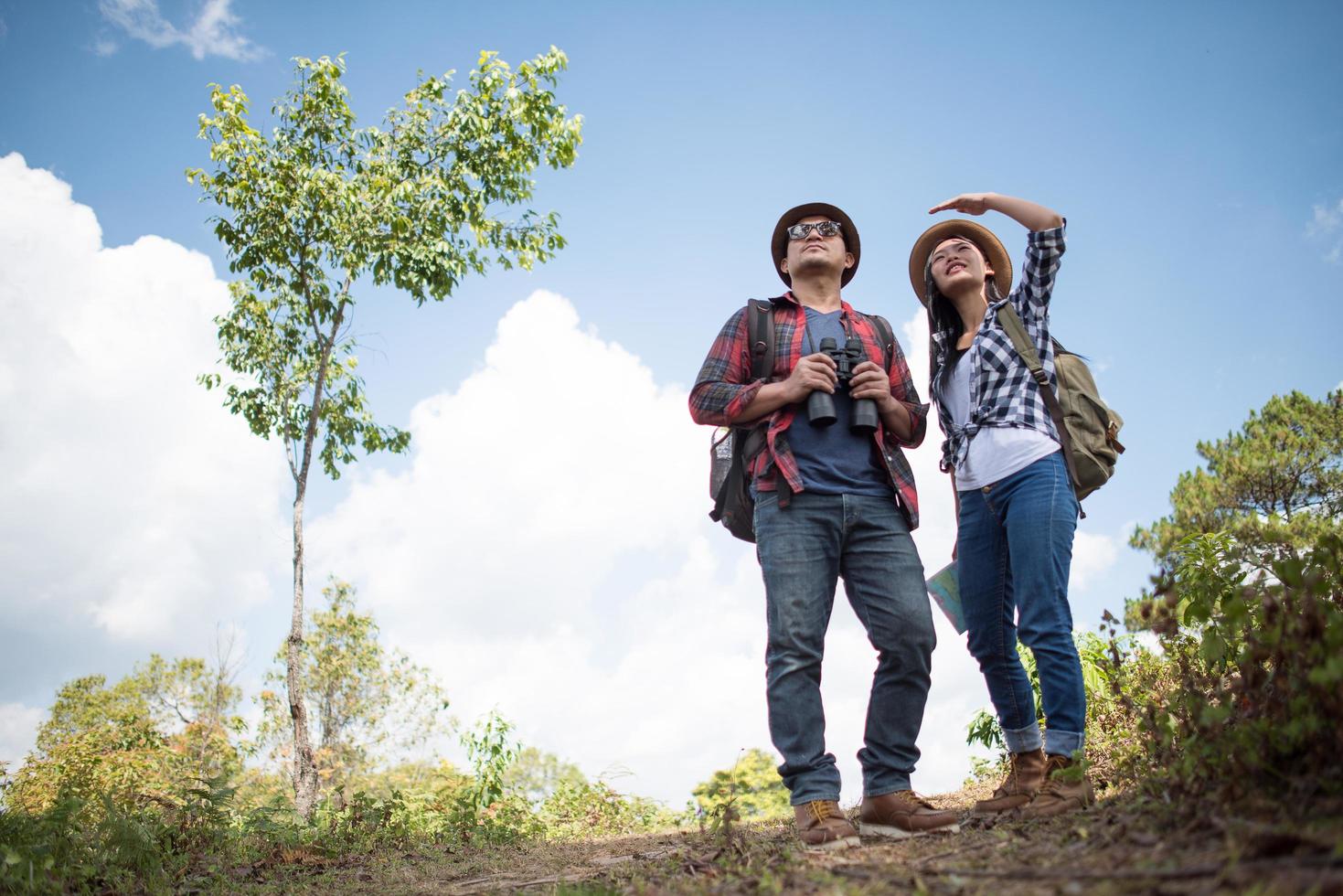 två unga resenärer med ryggsäckar i grön djungel foto